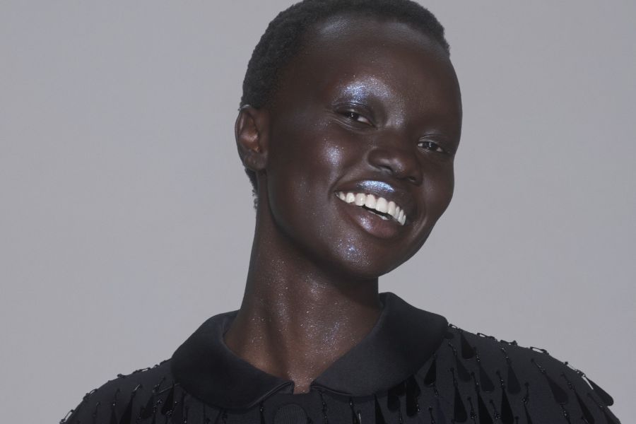 person smiling at camera with shiny makeup